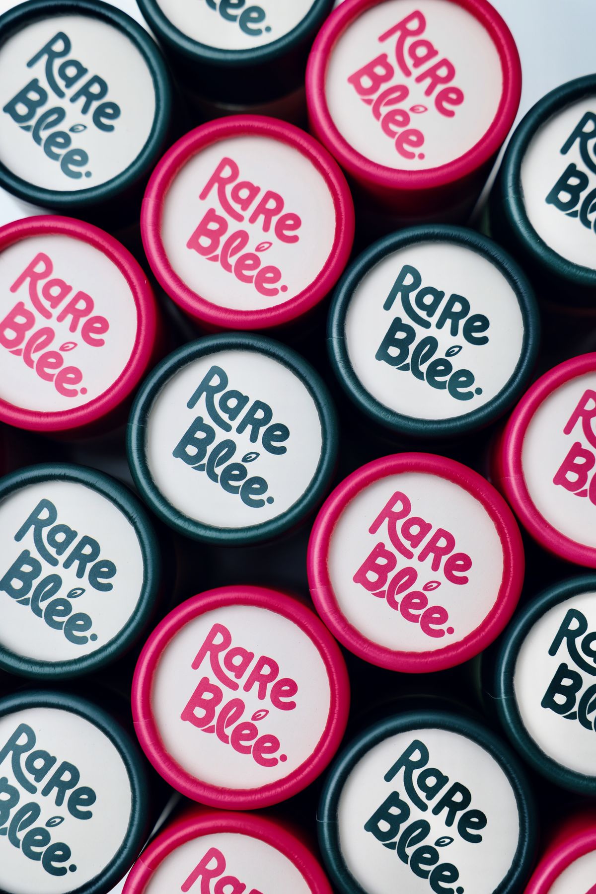 RareBlee branded caps in pink and green from above