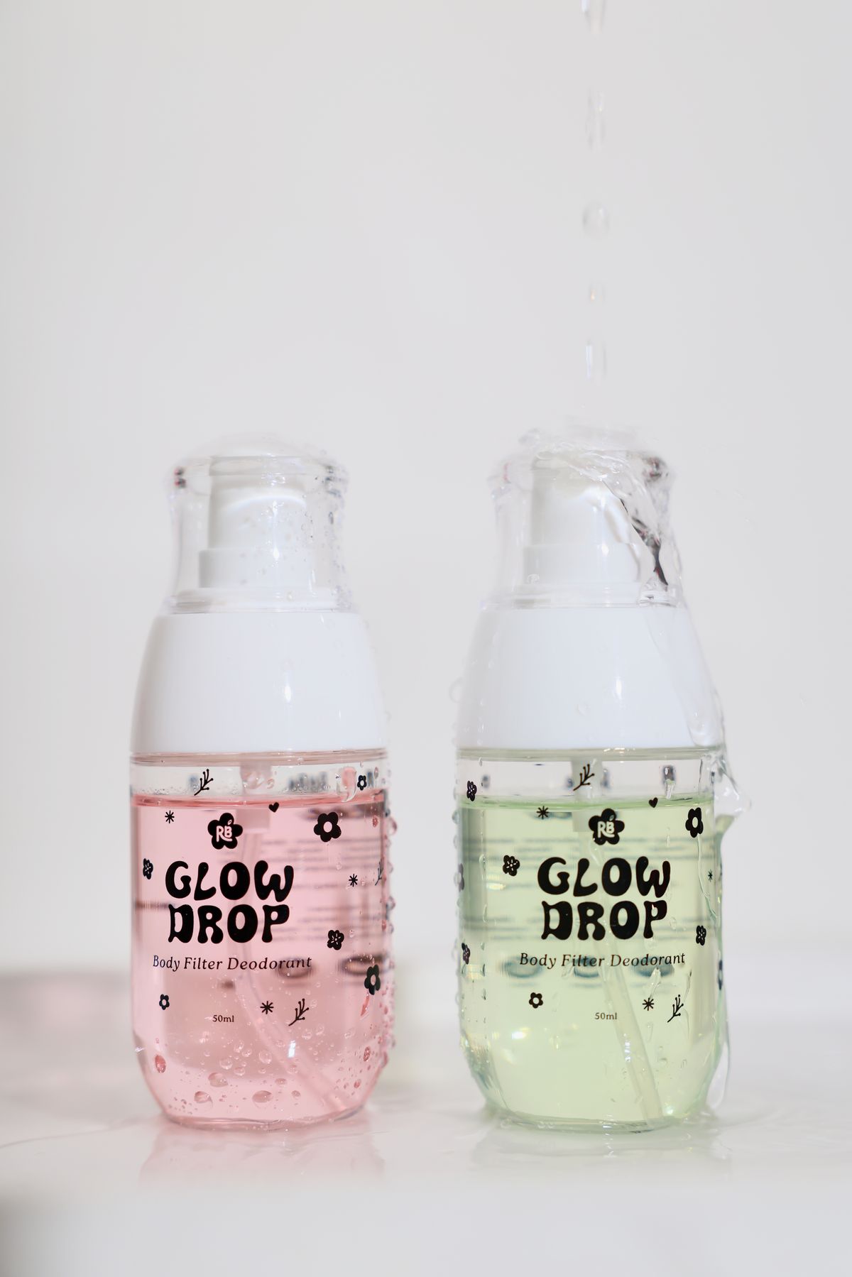 Glow Drop Pink Bloom and Green Bliss foam bottles with water droplets