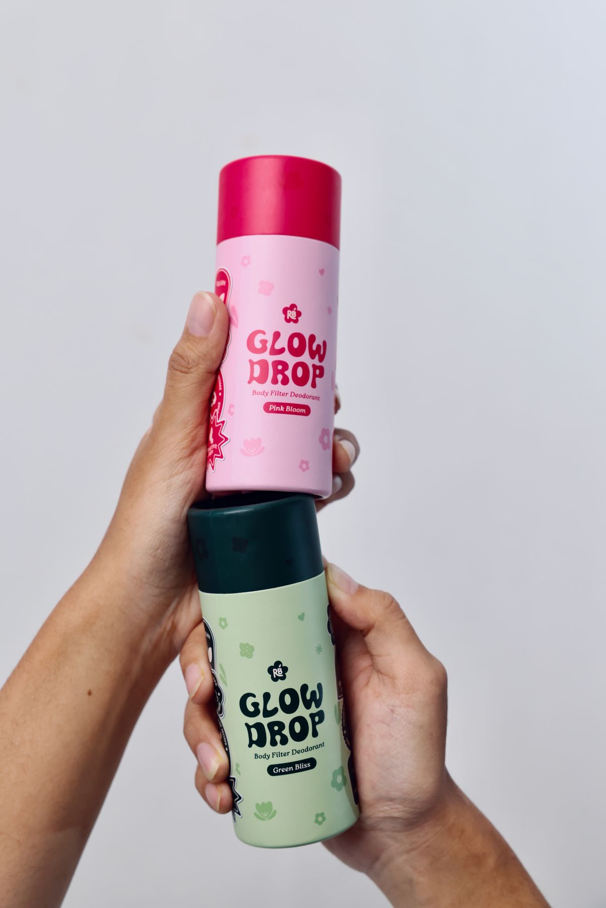 Hands holding Glow Drop Pink Bloom and Green Bliss